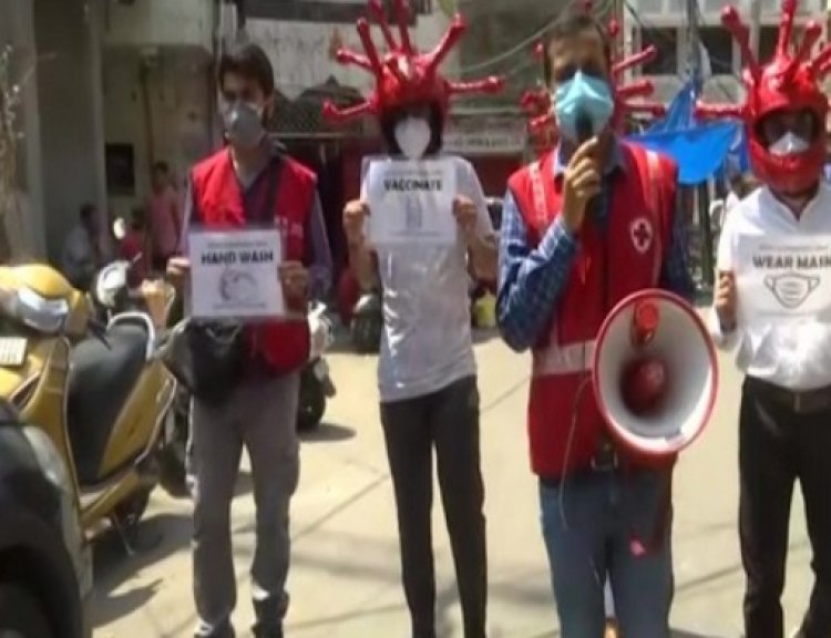 Volunteers wear virus-shaped helmets to create awareness about following Covid protocols in Jammu