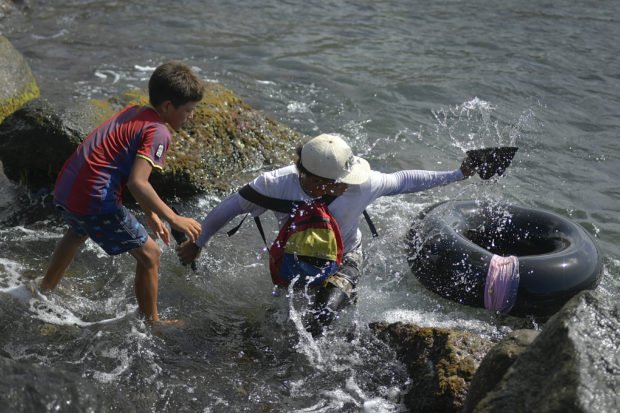 Venezuelans brave open sea on tubes, fishing for survival